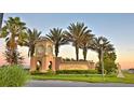 Community entrance sign for ChampionsGate surrounded by beautiful landscaping and palm trees at 1433 Bunker Dr, Davenport, FL 33896