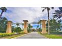ChampionsGate community entrance welcomes visitors with lush landscaping and stately columns at 1433 Bunker Dr, Davenport, FL 33896