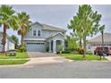 Two-story home featuring a well-manicured lawn, paved driveway, and a two-car garage at 1433 Bunker Dr, Davenport, FL 33896