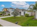 Inviting single-story home with a two-car garage, manicured lawn, and lush landscaping, ideal for comfortable living at 1719 Durden Dr, Winter Haven, FL 33880