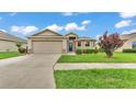 Inviting home showcasing a manicured lawn, stone details, and an attached two-car garage at 1765 Kingsmill Dr, Bartow, FL 33830