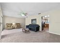 Bright living room featuring plush carpet and a ceiling fan at 1810 Roanoke Ave, Lakeland, FL 33803