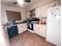 Cozy kitchen with tiled floors and white cabinets, offering ample storage and functionality at 1836 N Crystal Lake Dr, Lakeland, FL 33801