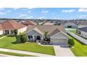 Aerial view of a well-maintained single-story home with manicured lawn and landscaping in a residential community at 204 Walkers Point Dr, Auburndale, FL 33823