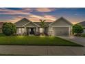 Beautiful single-story home featuring a landscaped yard, a cozy front porch with chairs, and an attached garage at 204 Walkers Point Dr, Auburndale, FL 33823