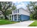 Two-story home with blue lower and white upper exterior, a concrete driveway, and landscaping at 2052 W Elliott St, Lakeland, FL 33805