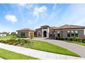 Charming front exterior with manicured lawn, paver driveway, and beautiful facade at 209 Pine Lilly Ct, Lake Alfred, FL 33850