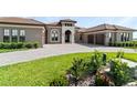Lovely front exterior view featuring a well-manicured lawn and a paved driveway at 209 Pine Lilly Ct, Lake Alfred, FL 33850
