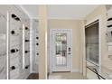 Elegant foyer with modern wine rack, stylish lighting, and a sleek glass console table at 2612 San Simeon Way, Kissimmee, FL 34741