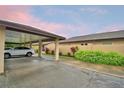 Attached carport featuring parking and landscaping. Single story home with neutral wall paint and dark brown roof at 2835 Wingfoot Ct, Winter Haven, FL 33884
