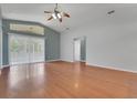 Bright living room with wood floors, a ceiling fan and large glass sliding door with transom window at 362 Lake Daisy Cir, Winter Haven, FL 33884