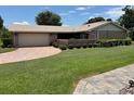 Well-maintained single-story home with a lush green lawn and paved driveway at 381 Troon Ct, Winter Haven, FL 33884