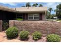 Cozy single-story home featuring a charming brick wall and mature landscaping at 381 Troon Ct, Winter Haven, FL 33884