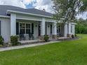 Charming front porch with classic rocking chairs and brick-detailed support pillars at 3985 Mammoth Grove Rd, Lake Wales, FL 33898