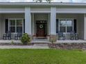 Inviting front porch featuring stately columns and comfortable seating, perfect for relaxing at 3985 Mammoth Grove Rd, Lake Wales, FL 33898