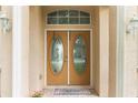 Elegant double front door with decorative glass inserts and sidelights at 4338 Dinner Lake Blvd, Lake Wales, FL 33859