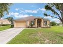 Inviting single-story home featuring an attached two car garage and well-maintained lawn at 4338 Dinner Lake Blvd, Lake Wales, FL 33859