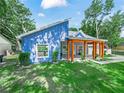 Attractive blue home with a modern design, inviting porch, and lush green lawn at 7714 Chase Rd, Lakeland, FL 33810