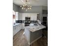Bright kitchen features white cabinets, granite countertops and stainless steel appliances at 7929 Ashley Pointe Dr, Lakeland, FL 33810