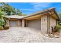 View of three car garage with brick exterior and a paved driveway on a sunny day at 105 Woden Way, Winter Haven, FL 33884