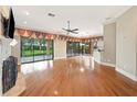 Spacious living room with wood floors, fireplace, ceiling fan, and sliding glass doors at 105 Woden Way, Winter Haven, FL 33884