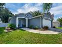 Inviting single-story home with a blue door, manicured lawn, and a charming front yard landscape at 124 Eagle Point Blvd, Auburndale, FL 33823