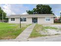 Inviting single-story home with a walkway leading to the front door, and bright windows at 1476 Avenue F Ne, Winter Haven, FL 33881