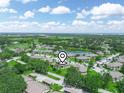 This aerial view shows the community surrounded by trees, a pond, and a golf course at 1507 Eagle Pond Dr # 1507, Winter Haven, FL 33884