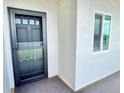 Condo unit entrance door with glass storm door and a window allowing natural light into the condo at 1776 6Th Street Nw # 709, Winter Haven, FL 33881