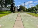 Community shuffleboard court with benches for players to rest on and green foliage in the background at 1776 6Th Street Nw # 709, Winter Haven, FL 33881
