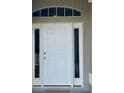 A close-up view of the white front door with side windows, enhancing curb appeal and natural light at 1790 Turtle Rock Dr, Lakeland, FL 33803