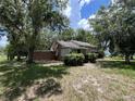 Quaint home exterior with mature trees and shrubbery, offering a serene and private setting at 1805 S Lake Reedy Blvd, Frostproof, FL 33843