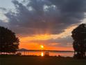 Picturesque waterfront view featuring a stunning sunset over a serene lake and a charming gazebo at 1805 S Lake Reedy Blvd, Frostproof, FL 33843