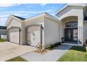 Home's exterior showing the garage and front door with meticulous landscaping at 185 St Thomas Dr, Mulberry, FL 33860
