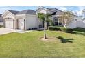 Charming home with a manicured lawn, featuring a palm tree and lush landscaping at 185 St Thomas Dr, Mulberry, FL 33860