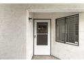 Close-up of the unit's front door, featuring a screen door, modern hardware, and a Ring security system at 2037 San Marcos Se Dr # 443, Winter Haven, FL 33880