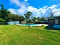 Spacious backyard featuring lush green grass, an in-ground pool, and a shaded patio area at 2159 Greenway Dr, Winter Haven, FL 33881