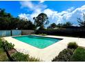 Refreshing in-ground pool surrounded by a concrete deck and lush landscaping in a private backyard at 2159 Greenway Dr, Winter Haven, FL 33881