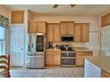 Bright kitchen with stainless steel appliances, tan cabinets, and tiled floor at 2252 Fox Run Rd, Lake Wales, FL 33898