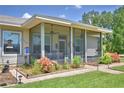The screened porch area is surrounded by small, colorful plants and includes a ceiling fan at 2252 Fox Run Rd, Lake Wales, FL 33898