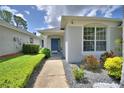 Home featuring well-manicured landscaping, walkways, and a bright blue front door at 2350 Paulette Dr, Haines City, FL 33844