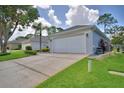 Two-car garage with wide driveway and well-manicured lawn at 2350 Paulette Dr, Haines City, FL 33844