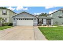 Charming single-story home with a two-car garage, green lawn, and landscaped front at 2602 Whitewood Rd, Mulberry, FL 33860