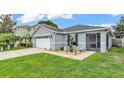 Light-grey single-story home featuring an attached two-car garage and a screened in porch at 2602 Whitewood Rd, Mulberry, FL 33860
