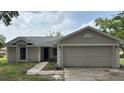 Charming single-story home featuring an attached two-car garage and a concrete driveway at 300 E Washington St, Minneola, FL 34715