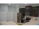 Modern kitchen with stainless steel appliances, dark cabinets, and quartz countertops at 3023 Caneel, Winter Haven, FL 33884