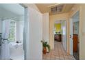 Hallway view showcasing access to the bathroom and a bright bedroom with a yellow accent wall at 304 W Lake Ave, Auburndale, FL 33823
