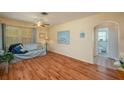 Cozy living room featuring wood floors, a ceiling fan, and a glimpse into an adjacent bathroom at 304 W Lake Ave, Auburndale, FL 33823