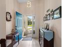 Bright foyer featuring tile flooring, blue front door, and stylish decor at 348 Lake Suzanne Dr, Lake Wales, FL 33859