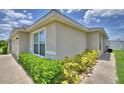 Corner view of the property featuring a well-maintained garden and pathway at 373 St Georges Cir, Eagle Lake, FL 33839